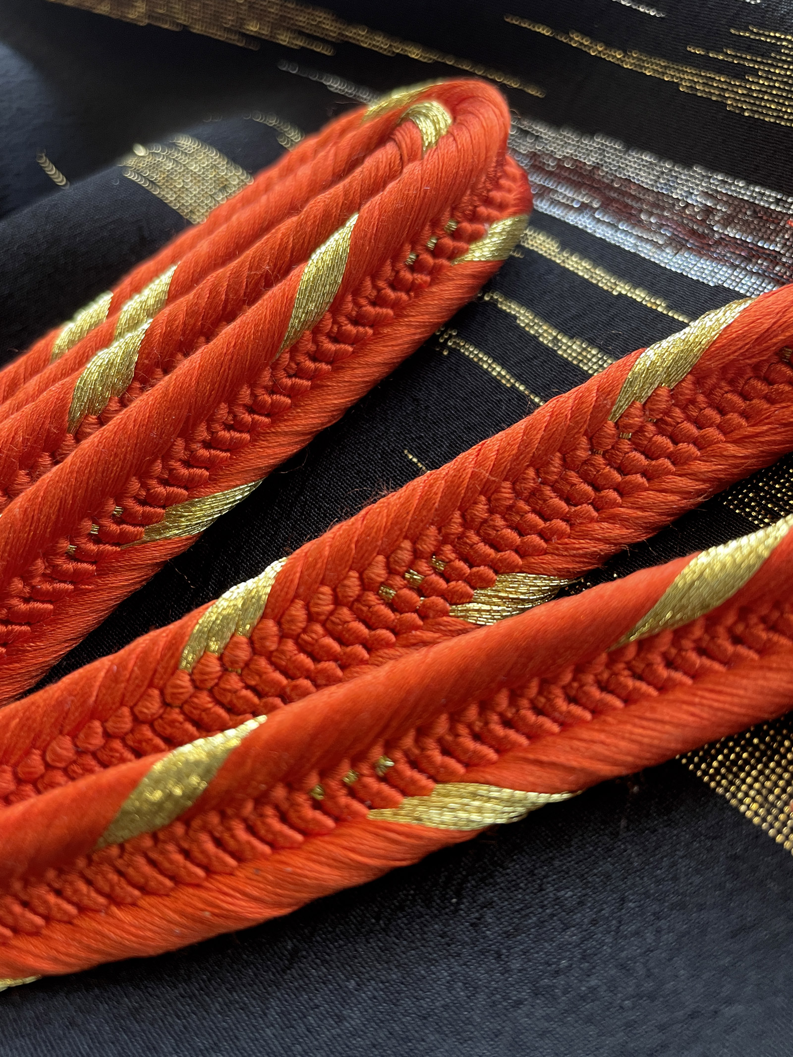 Bright orange silk cord with golden details