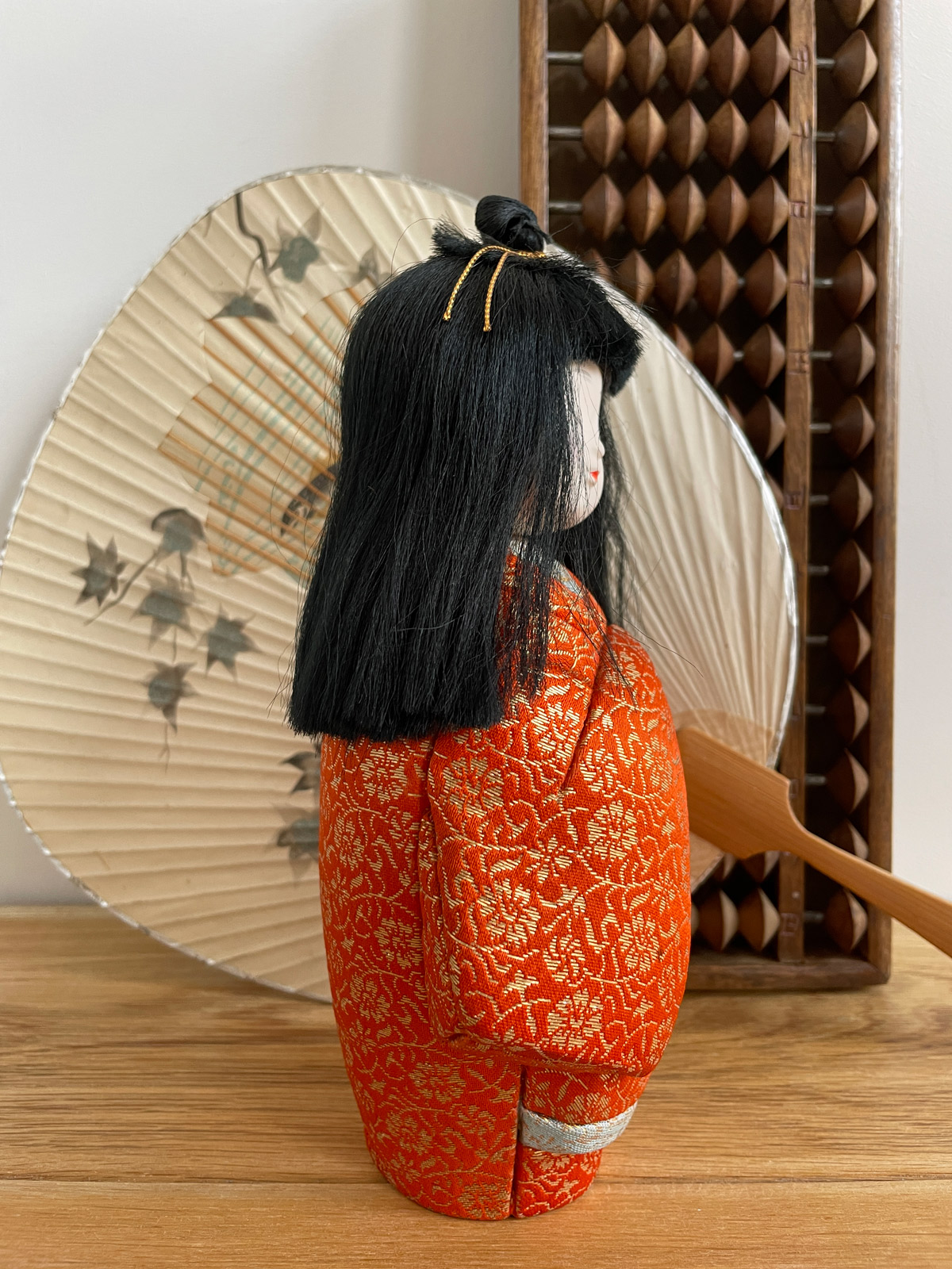 Kimekomi doll wearing bright orange Kimono