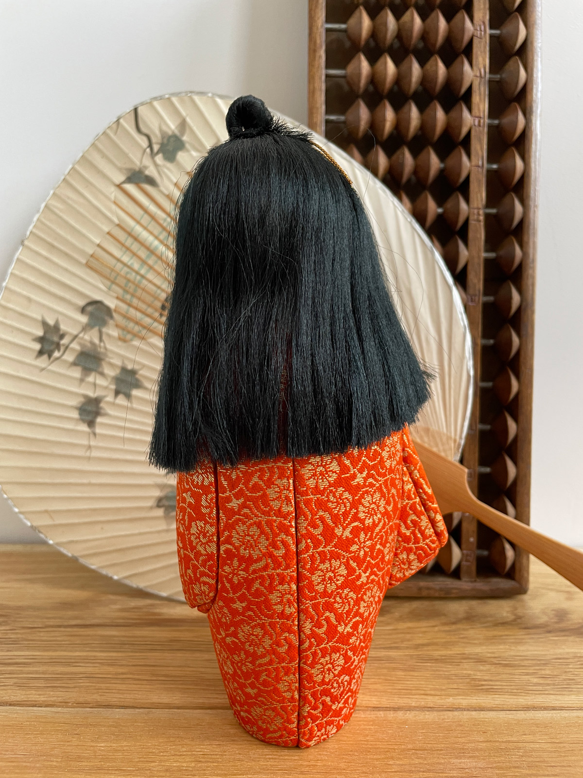 Kimekomi doll wearing bright orange Kimono